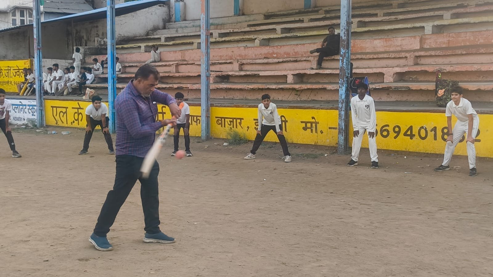 Free cricket camp at Gandhi Ground; young players hold leather balls and learn the intricacies
